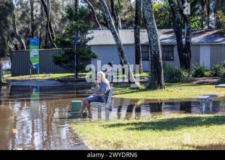 Samedi 6 avril 2024. Sydney a été frappée par un déluge de pluie au cours des dernières 48 heures, avec certaines zones, y compris Penrith recevant les précipitations les plus abondantes jamais enregistrées, à Narrabeen les résidents autour du lagon de Narabeen, sur la photo, ont été invités à évacuer en raison de la montée des niveaux d'eau du lac Narrabeen sur les plages du nord de Sydney. où plus de 150 mm de pluie sont tombés. Il y a eu plus de 50 observateurs d'inondations le long des rivières en Nouvelle-Galles du Sud et le barrage de Warragamba devrait se déverser. Homme âgé sur la photo est assis o na banc de parc dans les eaux de crue à côté du lac. Créditez Martin Berry @alamy Live news. Banque D'Images