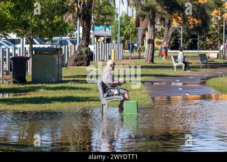 Samedi 6 avril 2024. Sydney a été frappée par un déluge de pluie au cours des dernières 48 heures, avec certaines zones, y compris Penrith recevant les précipitations les plus abondantes jamais enregistrées, à Narrabeen les résidents autour du lagon de Narabeen, sur la photo, ont été invités à évacuer en raison de la montée des niveaux d'eau du lac Narrabeen sur les plages du nord de Sydney. où plus de 150 mm de pluie sont tombés. Il y a eu plus de 50 observateurs d'inondations le long des rivières en Nouvelle-Galles du Sud et le barrage de Warragamba devrait se déverser. Homme âgé photographié assis sur un banc de parc dans les eaux de crue au bord du lac. Créditez Martin Berry @alamy Live news. Banque D'Images