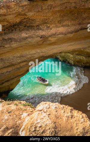 Les touristes en bateau explorent les eaux turquoises à l'intérieur de la grotte de Benagil en Algarve, Portugal. Banque D'Images