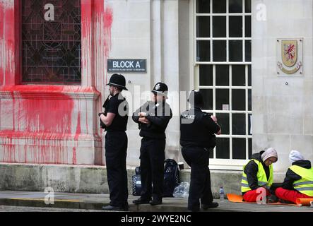 Des policiers observent les militants de Palestine action alors qu'ils se bloquent lors d'une manifestation devant la salle du comté de Somersetís. Les partisans de Palestine action utilisent le verrouillage pour bloquer l'entrée du County Hall et pulvériser de la peinture rouge sur l'extérieur du bâtiment. Les manifestants demandent au conseil municipal de Somerset de résilier le bail des bureaux qu'ils ont loués à Elbit Systems à Aztec West, Bristol. Ils soutiennent que les armes fabriquées par Elbit Systems au Royaume-Uni sont utilisées par les Forces de défense israéliennes contre les Palestiniens à Gaza et ailleurs. Les bombardements israéliens à Gaza ont tué plus de 30 000 Palestiniens depuis octobre Banque D'Images