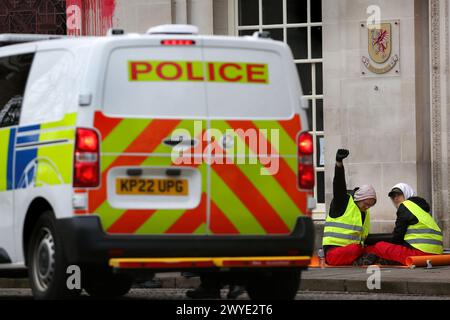 Un manifestant attaché à un lock-on lève le poing lors d'une démonstration de défiance lors d'une manifestation devant la salle du comté de Somersetís. Les partisans de Palestine action utilisent des verrous pour bloquer l'entrée du County Hall et vaporiser de la peinture rouge sur l'extérieur du bâtiment. Les manifestants demandent au conseil municipal de Somerset de résilier le bail des bureaux qu'ils ont loués à Elbit Systems à Aztec West, Bristol. Ils soutiennent que les armes fabriquées par Elbit Systems au Royaume-Uni sont utilisées par les Forces de défense israéliennes contre les Palestiniens à Gaza et ailleurs. Les bombardements israéliens à Gaza ont tué plus de 30 000 Palestiniens depuis O Banque D'Images