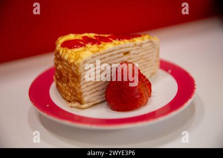 Gâteau à la crêpe aux fraises en couches garni et arrosé de sauce Banque D'Images