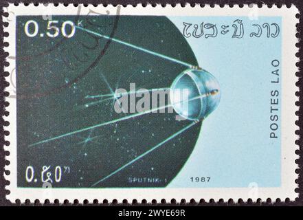 Timbre-poste annulé imprimé par le Laos, qui montre le satellite 'Spoutnik-1', vers 1987. Banque D'Images