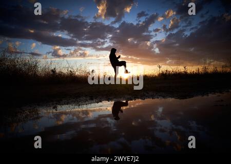 Photographie prise à l'heure dorée où vous pouvez voir une figure contre la lumière qui brille avec le soleil Banque D'Images