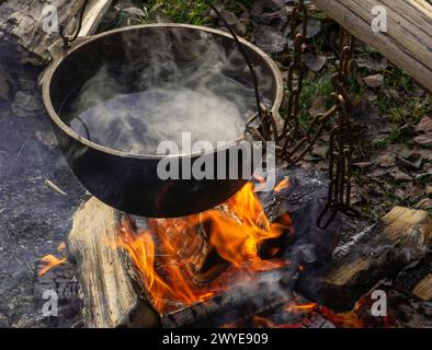 Pot sur le feu. L'eau bout dans un chaudron au-dessus d'un feu. Banque D'Images