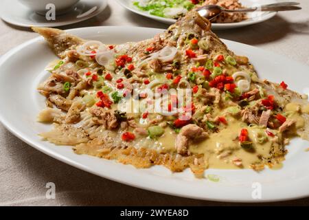 Skate Wing ou Ray Wing préparé entier avec une sauce mayonnaise au thon et du poivron rouge Banque D'Images