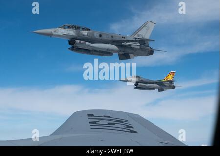 Deux F-16 de la Republic of Singapore Air Force volent aux côtés d'un KC-135 Stratotanker de la Garde nationale de l'air de Washington pendant Cope Tiger 2024 Banque D'Images