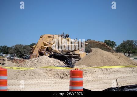 Équipement d'excavation nivelant les collines du Texas Hill Country pour soutenir l'étalement urbain, que beaucoup voient comme une transformation négative à la vie rurale/ranch. Banque D'Images