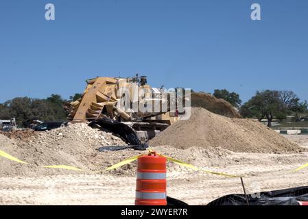 Équipement d'excavation nivelant les collines du Texas Hill Country pour soutenir l'étalement urbain, que beaucoup voient comme une transformation négative à la vie rurale/ranch. Banque D'Images