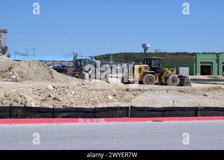 Équipement d'excavation nivelant les collines du Texas Hill Country pour soutenir l'étalement urbain, que beaucoup voient comme une transformation négative à la vie rurale/ranch. Banque D'Images