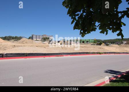 Équipement d'excavation nivelant les collines du Texas Hill Country pour soutenir l'étalement urbain, que beaucoup voient comme une transformation négative à la vie rurale/ranch. Banque D'Images