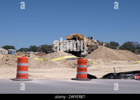 Équipement d'excavation nivelant les collines du Texas Hill Country pour soutenir l'étalement urbain, que beaucoup voient comme une transformation négative à la vie rurale/ranch. Banque D'Images