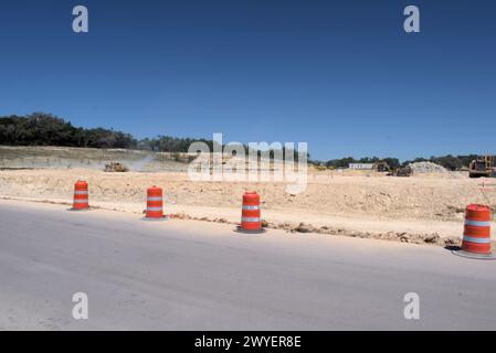 Équipement d'excavation nivelant les collines du Texas Hill Country pour soutenir l'étalement urbain, que beaucoup voient comme une transformation négative à la vie rurale/ranch. Banque D'Images