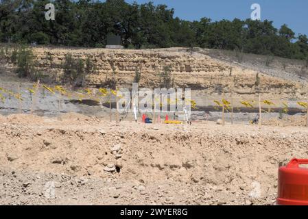 Équipement d'excavation nivelant les collines du Texas Hill Country pour soutenir l'étalement urbain, que beaucoup voient comme une transformation négative à la vie rurale/ranch. Banque D'Images