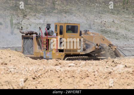 Équipement d'excavation nivelant les collines du Texas Hill Country pour soutenir l'étalement urbain, que beaucoup voient comme une transformation négative à la vie rurale/ranch. Banque D'Images