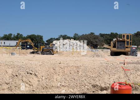 Équipement d'excavation nivelant les collines du Texas Hill Country pour soutenir l'étalement urbain, que beaucoup voient comme une transformation négative à la vie rurale/ranch. Banque D'Images