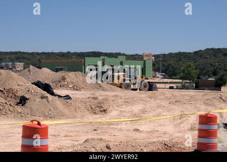 Équipement d'excavation nivelant les collines du Texas Hill Country pour soutenir l'étalement urbain, que beaucoup voient comme une transformation négative à la vie rurale/ranch. Banque D'Images