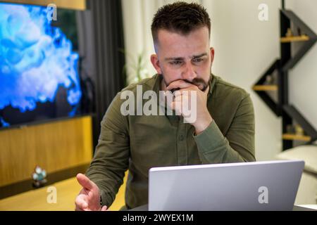 Un jeune albanais barbu travaillant sur son carnet de notes depuis chez lui. Banque D'Images