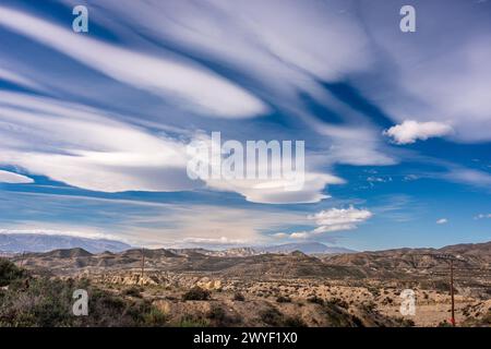 Des nuages striés s'étendent à travers le ciel au-dessus du terrain aride du désert de Tabernas à Almeria, Andalousie. Banque D'Images