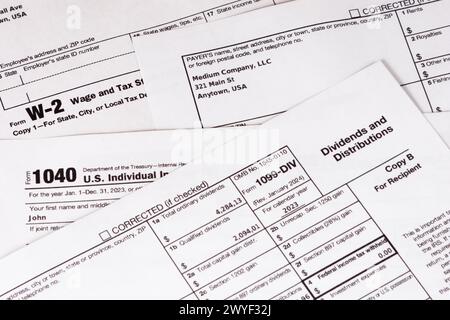 Lombard, il, États-Unis - 5 avril 2024 : divers formulaires fiscaux IRS avec des informations personnelles fabriquées soigneusement arrangées. Banque D'Images