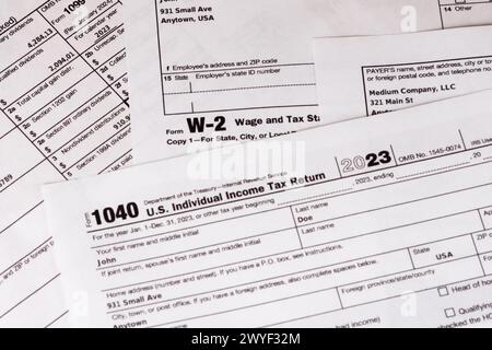 Lombard, il, États-Unis - 5 avril 2024 : divers formulaires fiscaux IRS avec des informations personnelles fabriquées soigneusement arrangées. Banque D'Images