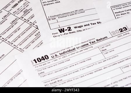 Lombard, il, États-Unis - 5 avril 2024 : divers formulaires fiscaux IRS avec des informations personnelles fabriquées soigneusement arrangées. Banque D'Images