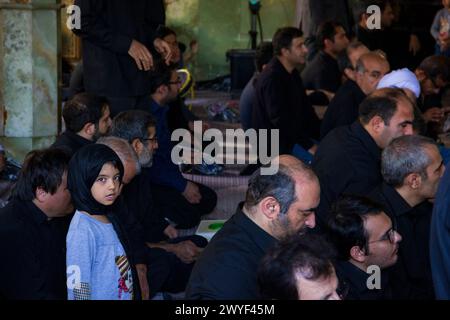 Petite fille musulmane à côté de son père dans une mosquée pendant que les hommes disent leurs prières. Banque D'Images