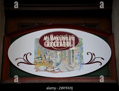 'Au marché de Riquewihr' une enseigne ovale antique en bois d'une épicerie fine artisanale locale écrite en français à Riquewihr, Alsace France. Banque D'Images