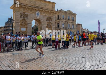 Montpellier, France. 6 avril 2024. Les participants du relais Ekiden courent devant l'Arc de Triomphe avec le public les encourageant. Rapport de crédit MPL/Alamy Live News Banque D'Images