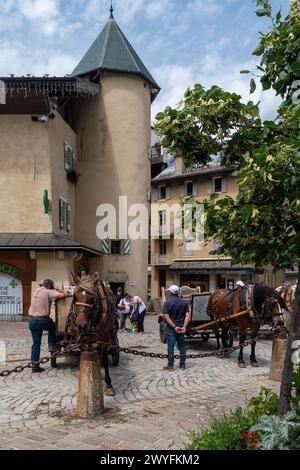 Calèches pour les promenades touristiques sous la Tour Magdelain sur la place du village alpin en été, Megève, haute Savoie, France Banque D'Images