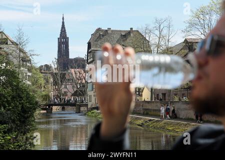 Strasbourg, France. 06 avril 2024. © PHOTOPQR/L'ALSACE/Roméo BOETZLÉ ; Strasbourg ; 06/04/2024 ; une personne buvant de l'eau devant une vue sur la cathédrale de Strasbourg le 6 avril 2024. France, 6 avril 2024 des températures qui rappellent davantage -juin qu’avril. Ce week-end du samedi 6 avril et du dimanche 7 avril promet d’être particulièrement chaud dans toute la France, avec des températures avoisinant parfois les 30 degrés. Un pic de chaleur anormal, parfois de plus de 10 degrés au-dessus des normes saisonnières, preuve éventuelle de l’impact du changement climatique. Crédit : MAXPPP/Alamy Live News Banque D'Images