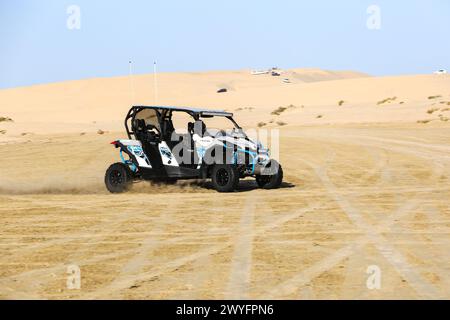 Une vue de buggys de dune étant conduit par les touristes dans un parc safari dans le désert dans les dunes de sable près de la mer intérieure. Banque D'Images