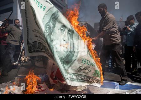 Téhéran, Iran. 5 avril 2024. Des manifestants iraniens brûlent une copie du dollar lors d'un rassemblement annuel pour marquer la Journée de Qods, ou Journée de Jérusalem, en soutien aux Palestiniens. Lors du rassemblement à Téhéran, des milliers de personnes ont assisté à un cortège funèbre pour les sept membres de la Garde révolutionnaire tués dans une frappe aérienne largement attribuée à Israël qui a détruit lundi le consulat iranien dans la capitale syrienne. (Crédit image : © Sobhan Farajvan/Pacific Press via ZUMA Press Wire) USAGE ÉDITORIAL SEULEMENT! Non destiné à UN USAGE commercial ! Banque D'Images