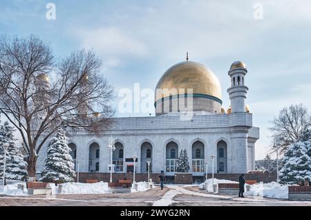 Almaty, Kazakhstan - 15 mars 2024 : immense mosquée centrale d'Almaty, construite en marbre blanc en 1999, avec dômes dorés, calligraphie céramique, imposant minar Banque D'Images
