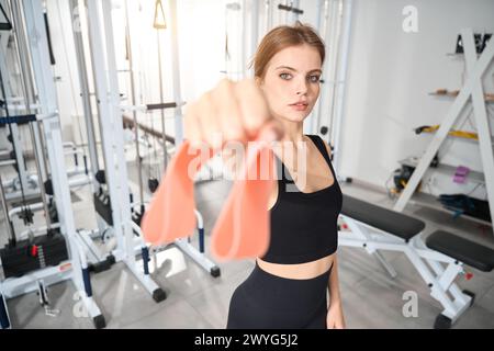 La jeune femme tient une bande élastique de fitness dans sa main Banque D'Images