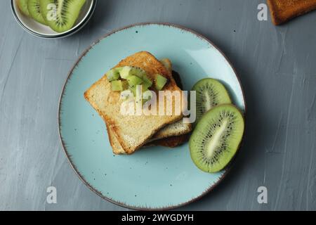 Pain kiwi sur assiette sur fond gris avec espace pour le texte. Petit déjeuner sain avec des fruits. Banque D'Images