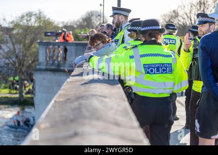 Samedi 30 mars 2024 Chiswick Bridge, Londres, Royaume-Uni. Les manifestants se sont rassemblés parmi les spectateurs qui regardaient la course de bateaux Gemini lors de la dernière course pour hommes. Les manifestants ont hissé des drapeaux palestiniens lors de la course finale et ont appelé à une Palestine libre afin de souligner le génocide continuel du peuple palestinien par Israël. Alors que Cambridge franchit la ligne d'arrivée, les membres du groupe Youth Demand ont laissé tomber une bannière et le drapeau palestinien. La police est rapidement intervenue et a enlevé le drapeau et la bannière, mais deux jeunes hommes ont réussi à se coller sur le pont. Abdullah Bailey/Alamy Live News Banque D'Images