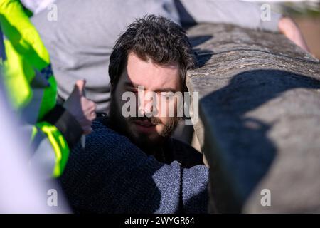 Samedi 30 mars 2024 Chiswick Bridge, Londres, Royaume-Uni. Les manifestants se sont rassemblés parmi les spectateurs qui regardaient la course de bateaux Gemini lors de la dernière course pour hommes. Les manifestants ont hissé des drapeaux palestiniens lors de la course finale et ont appelé à une Palestine libre afin de souligner le génocide continuel du peuple palestinien par Israël. Alors que Cambridge franchit la ligne d'arrivée, les membres du groupe Youth Demand ont laissé tomber une bannière et le drapeau palestinien. La police est rapidement intervenue et a enlevé le drapeau et la bannière, mais deux jeunes hommes ont réussi à se coller sur le pont. Abdullah Bailey/Alamy Live News Banque D'Images