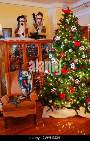 Un arbre de Noël avec des décorations et des cadeaux se trouve dans un salon confortable pendant les vacances Banque D'Images