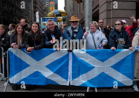 New York, États-Unis. 06 avril 2024. Les fêtards arborent des drapeaux écossais lors de la 26e parade annuelle du jour du tartan de New York sur la Sixième Avenue. Le défilé annuel commémorant la culture écossaise attire des cornemuses, des danseurs des Highlands, des organisations écossaises-américaines et des fêtards à Midtown Manhattan, New York City. En 1998, le Sénat des États-Unis a proclamé le 6 avril Journée nationale du tartan « pour reconnaître les réalisations exceptionnelles et les contributions apportées par les Écossais américains aux États-Unis ». Crédit : SOPA images Limited/Alamy Live News Banque D'Images