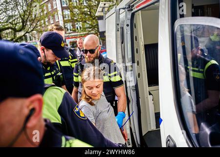 La Haye, pays-Bas. 06 avril 2024. Greta Thunberg a été arrêtée avec d'autres manifestants alors qu'elle bloquait la route (S100) dans le centre de la Haye. Un petit groupe de manifestants a bloqué la route (S100) dans le centre de la Haye lors d'un mouvement de rébellion d'extinction. Au départ, les activistes voulaient bloquer l'A12 pour la 37e fois, mais ils n'ont pas réussi à prendre la route car un policier les a encerclés et arrêtés. Les manifestants portaient des drapeaux « XR » et des pancartes disant « arrêtez les subventions au carburant maintenant ! » Et 'la planète est en train de mourir!'. Crédit : SOPA images Limited/Alamy Live News Banque D'Images