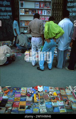 Homme regardant des livres vendus sur le trottoir, pris en 1999, Old Delhi district, New Delhi, Inde Banque D'Images