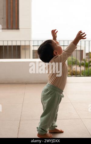 Bébé avec ses mains levées voulant être ramassé par quelqu'un Banque D'Images