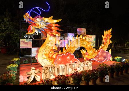 Lanterne en forme de dragon brillante lors d'un festival de nuit, entourée de décorations plus petites Banque D'Images