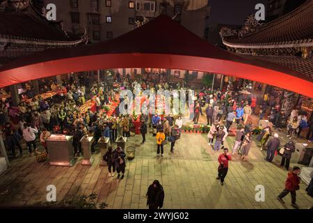 Des dévots priant dans le temple de Baoan rempli de fumée d'encens, lors d'une cérémonie du nouvel an chinois Banque D'Images