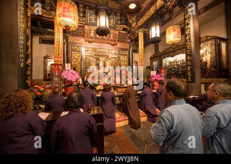 Dévots avec offrandes lors d'une cérémonie religieuse pour le nouvel an chinois dans le temple de Baoan Banque D'Images