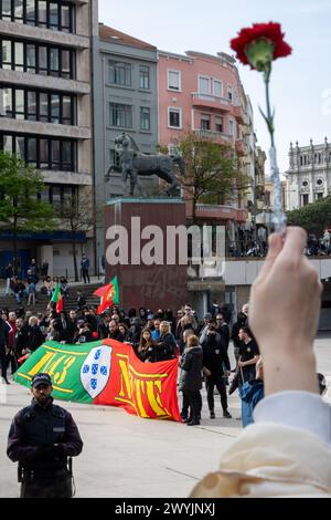 Un sympathisant antifasciste est vu tenant un oeillet (fleur) devant la manifestation d'extrême droite. Environ deux cents manifestants d'extrême droite ont manifesté à Porto contre l'immigration. La manifestation était dirigée par Mário Machado et, en cours de route, des émotions se sont enflammées : d’un côté, des manifestants d’extrême droite et de l’autre, des dizaines de personnes luttant contre le fascisme. La PSP (Polícia de Segurança Pública 'police') a arrêté au moins trois jeunes. La manifestation contre les immigrés n'a rassemblé que 200 personnes, tandis que l'autre manifestation, antifasciste, en a rassemblé des milliers. (Photo de Diogo Banque D'Images
