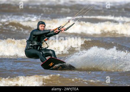 Kite surfer, Southport, Merseyside. 04/07/24. Un kitesurf profite pleinement de la tempête Kathleen qui déferle les vagues et les vents forts qui poussent le long des rives de Southport Beach dans le Merseyside. Crédit : Cernan Elias/Alamy Live News Banque D'Images