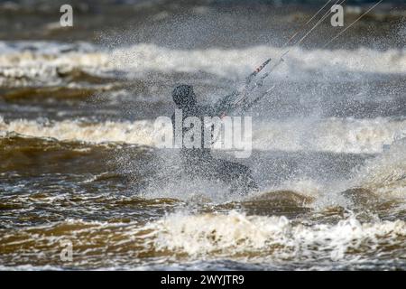 Kite surfer, Southport, Merseyside. 04/07/24. Un kitesurf profite pleinement de la tempête Kathleen qui déferle les vagues et les vents forts qui poussent le long des rives de Southport Beach dans le Merseyside. Crédit : Cernan Elias/Alamy Live News Banque D'Images