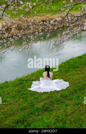 La jeune fille profite de Fukuoka Sakura floraison au bord de la rivière Banque D'Images